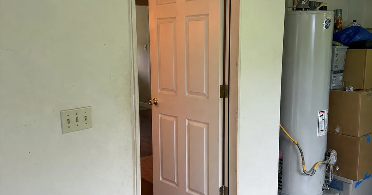 Attached-garage door into a Fontana house with a missing self-closing hinge and a gap at the top