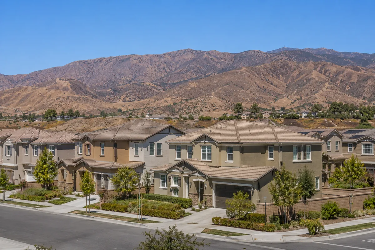 Wide view of a Rancho Cucamonga master-planned tract of newer tile-roof homes on graded pads below the San Gabriel foothills