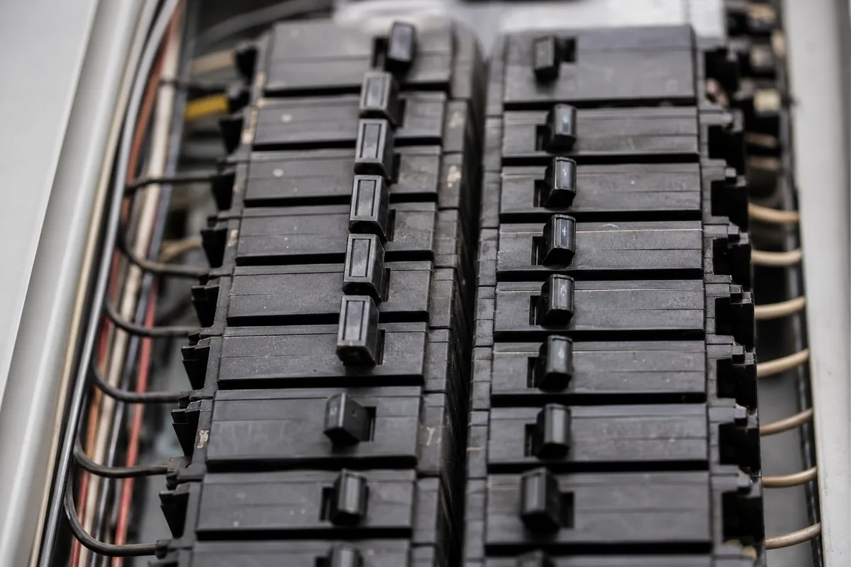 Modern residential electrical service panel with the dead-front cover removed, showing properly installed breakers and neat copper terminations as a reference baseline