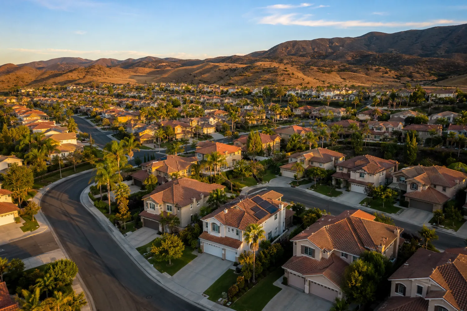Aerial view of the Tuscany Hills neighborhood in Lake Elsinore, a master-planned community of slab-on-grade single-family homes built mostly in the early 2000s, set against the dry foothills of the Inland Empire