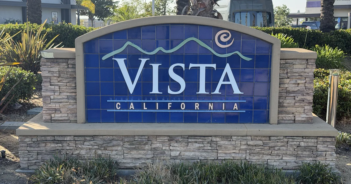 A stone monument sign reading Vista California at a shopping center entrance
