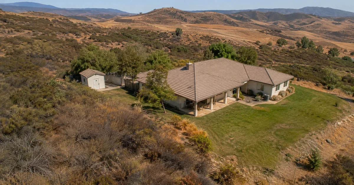 Aerial view of a Wildomar rural property near the Cleveland National Forest showing vegetation clearance zones around a home