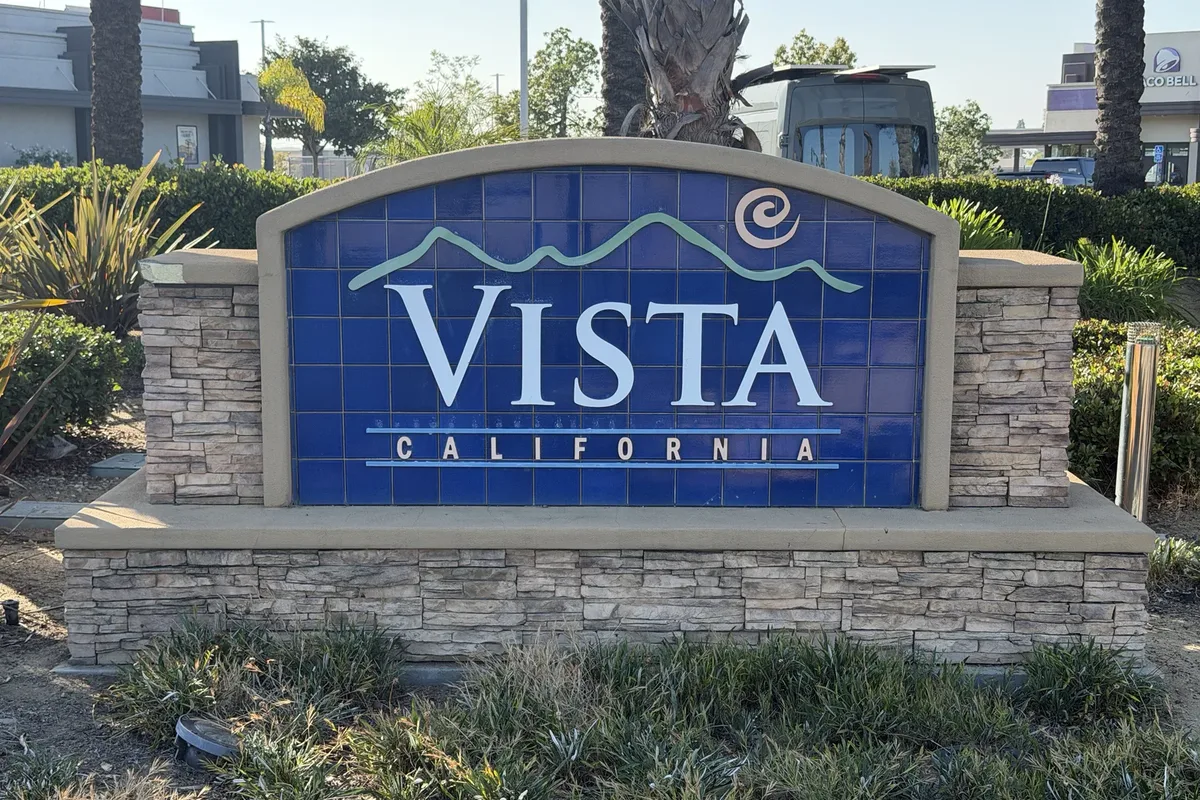 Blue tiled Vista, California monument sign set in a stacked stone base with landscaping around it
